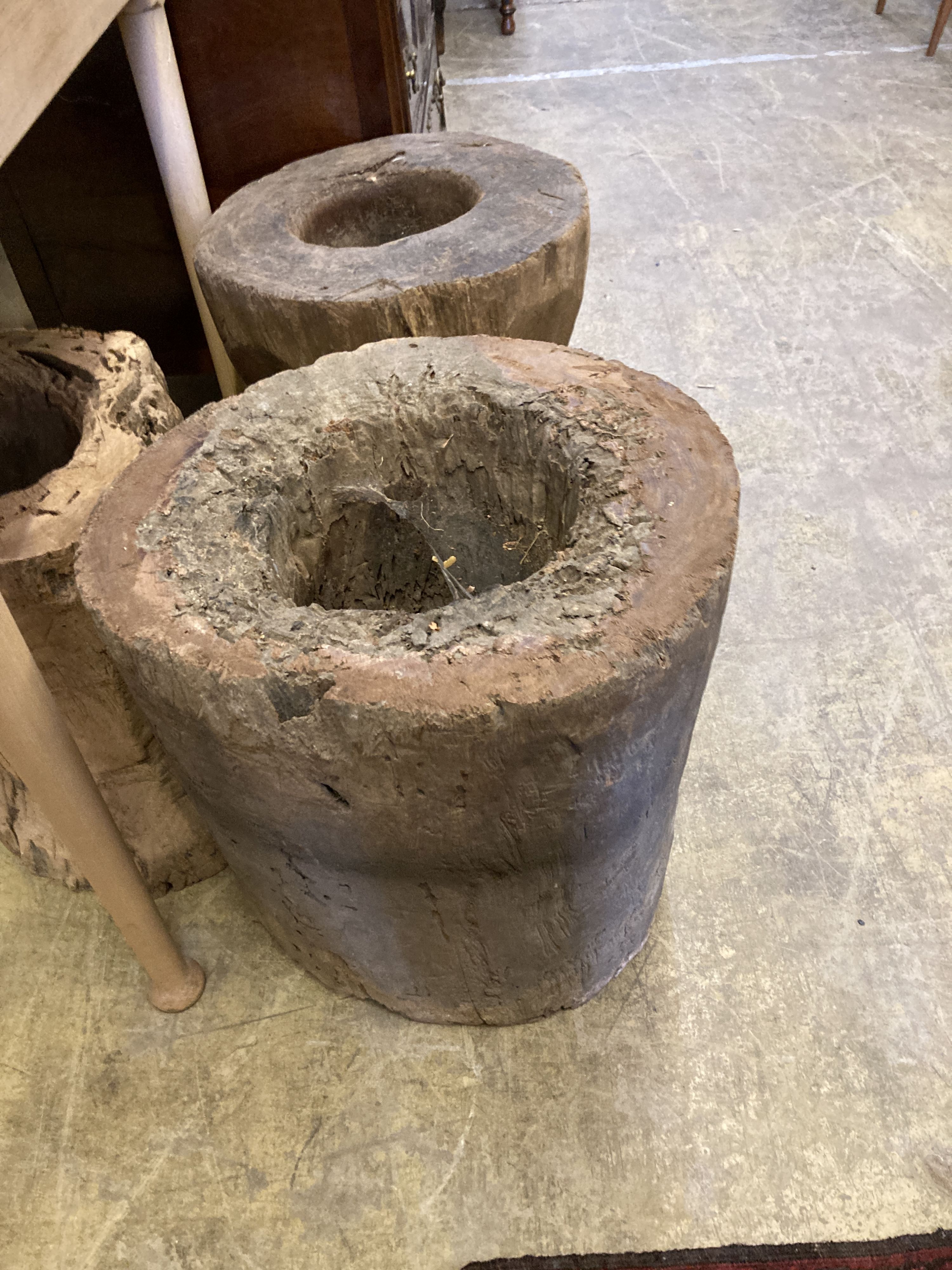 Three Indonesian hardwood rice mortars, largest 46cm high